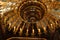 Large vintage shiny golden ceiling chandelier with illuminating electric candles inside cathedral, christian church on