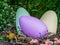 Large vivid colored easter eggs in a big birds nest, outdoor holiday decorations, spring season background