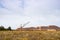 A large walking excavator forms dumps of rock delivered by freight train from a mining quarry. Background