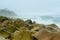 Large, water-worn stones lay on a rocky, rugged shoreline