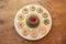 Large watermelon radish in a white bowl surrounded by radish slices on old wood background