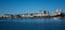 Large waterside houses, apartment condominiums in suburban community on riverfront with boats moored at wharf, blue sky in backgro