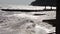 A large wave breaks about a breakwater close-up against a sunset background. Shot. Seascape. Sea water storm waves