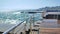 Large wave hitting wooden pier jetty with a lot of splashes on a sunny day.