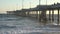 Large waves crashing to shore along an ocean pier