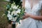 A large wedding bouquet in the hands of a beautiful bride