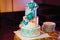Large wedding cake with three tiers of white blue glaze decorated with flowers and hearts