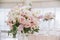 Large wedding flowers, white and cream roses, eucalyptus leaves decorate the banquet hall of the restaurant