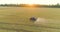 Large wheat field drone view. A tractor sprays a wheat field, a top view. Protecting fields from pests