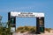 Large white banner over entrance to a beach that says, Beach Open Social Distance