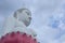 A large white Buddha image with a cloudy sky makes sense of tranquility
