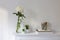 Large white chrysanthemum in a glass transparent vase and two artificial succulents on the table