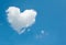 Large white cloud in the shape of a heart in the blue sky