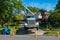 A large white heavy duty truck with a crane is seen with its front elevated wheels off of the ground by stabilizers