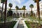 A large white manor on a cloudy day and palms