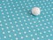 Large white marble ball amongst small dots on turquoise. Different, unique or just trying to adapt, fit in. Hiding in