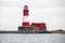 a large white and red lighthouse with a tower on top of it