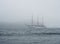 A large white sailboat floats on the sea through the strait