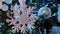 Large white snowflake in foreground, silver and white balls move, swing on Christmas tree against the background of