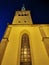 The large white St. Olaf Baptist Church on one of the streets of Old Tallinn against a dark blue sky. Spring evening