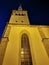 The large white St. Olaf Baptist Church on one of the streets of Old Tallinn against a dark blue sky. Spring evening