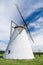 Large white windmill under blue sky