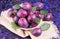 Large whole autumn blue plums in a plate on a blue background. Close-up.