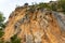 Large wild red limestone cliffs with sparse vegetation