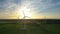 Large wind turbines with blades in field aerial view bright orange sunset blue sky wind park slow motion drone turn. Silhouettes