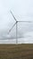 Large wind turbines with blades in the wind park on the background cloudy sky