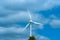 A large windmill on a background of blue sky with white clouds.