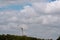 A large windmill on a background of blue sky with white clouds.