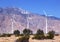 Large windmills in a clear blue sky against the backdrop of mountains