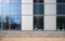 Large windows in an office building. Behind the glass are many indoor plants and flowers