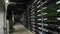 Large wired internet datacenter storage. Cryptocurrency mining equipment on large farm. ASIC miners on stand racks mine