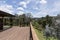 Large wood deck near house with spring landscape.