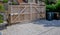 Large wooden entry electric gates with stone driveway