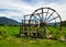 Large wooden turbine baler water wheel place on rice field and small canal at Thai-Dam Cultural Village in Chiang Khan, Loei Pro
