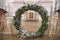 A large wreath of Advent from spruce branches as a gate to the old historical catholic church in winter day, Kurmene, Latvia