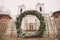 A large wreath of Advent from spruce branches as a gate to the old historical catholic church in winter day, Kurmene, Latvia