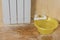 A large yellow bowl under a leaking radiator. Accident of the heating system of a private house.