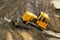 Large yellow caterpillar industrial tractor, iron dump shifts sand and ground, lines road for transport inside development of