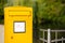 A large yellow German mailbox stands in front of a railing on the canal.