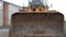 A large yellow loader with a large bucket rides straight to the camera, blurry, excavator, large bucket