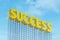 Large yellow signboard on metal frame with the word success