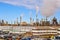 The largest Canadian oil refinery in the background, parking in the foreground, smoking pipes