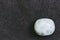 Larimar tumbled stone pebble on a black background with empty space
