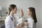 Laryngologist gives high five to child after checkup in clinic
