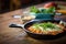 lasagna in cast iron skillet on a rustic wooden table