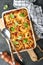 Lasagna. Homemade lasagna pasta rotolo bake with tomato sauce, cream cheese and basil on white skillet on dark slate, stone or